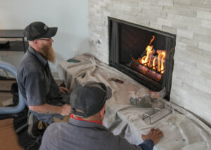 Chimney Technicians checking the new fireplace they installed.